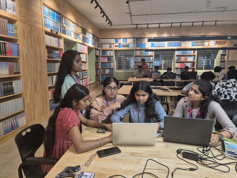 Students collaborating around a laptop during the Cambridge hackathon